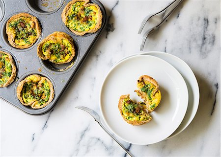 party dish - Mini quiches with courgette, bacon and parsley in a muffin tin Stock Photo - Premium Royalty-Free, Code: 659-08905341