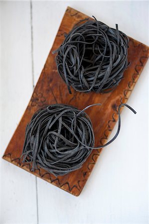 simsearch:659-07069841,k - Two pasta nests made of black sepia pasta on a wooden board Foto de stock - Sin royalties Premium, Código: 659-08905343