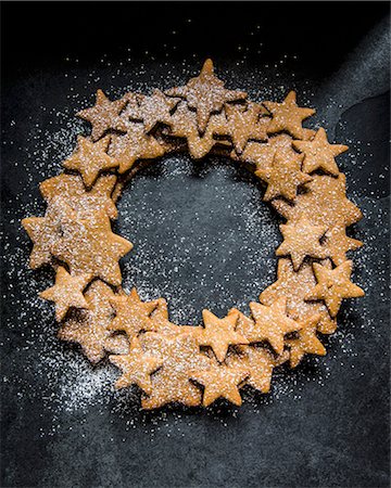 food, dark background - A wreath made of gingerbread stars dusted with icing sugar (seen from above) Stock Photo - Premium Royalty-Free, Code: 659-08905408