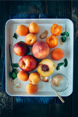 simsearch:659-07027082,k - Fruits with stones (apricots, peaches and nectarines) with brown sugar and mint leaves on a tray Photographie de stock - Premium Libres de Droits, Code: 659-08905647