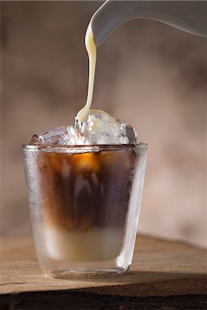 Sweetened condensed milkbeing poured into a glass of Vietnamese iced coffee Foto de stock - Sin royalties Premium, Código: 659-08906000