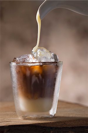 simsearch:659-08896141,k - Sweetened condensed milkbeing poured into a glass of Vietnamese iced coffee Stock Photo - Premium Royalty-Free, Code: 659-08906000