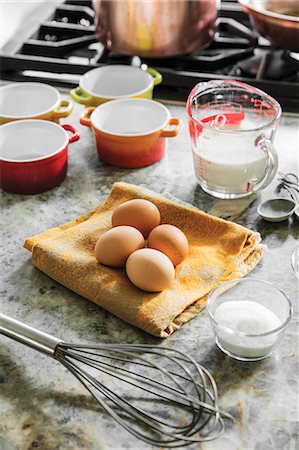 simsearch:659-07599076,k - Eggs, milk and sugar with a whisk and ramekins next to a gas stove Stock Photo - Premium Royalty-Free, Code: 659-08906060