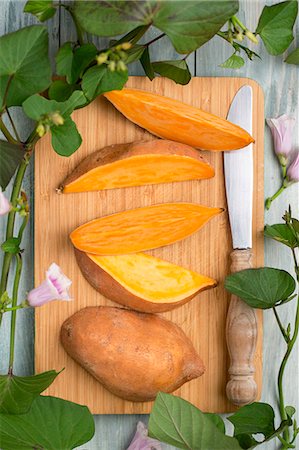 simsearch:659-07068816,k - A sliced sweet potato with sweet potato leaves and flowers Photographie de stock - Premium Libres de Droits, Code: 659-08906234