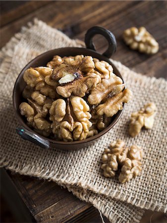 Walnuts in a small copper bowl on a wooden table Stock Photo - Premium Royalty-Free, Code: 659-08906420