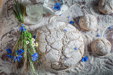 And unbaked loaf of bread and bread rolls withflower, water and ears of corn Stock Photo - Premium Royalty-Free, Code: 659-08906489