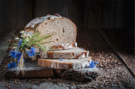 simsearch:659-07597603,k - Sliced healthy wholemeal bread on a board with ears of corn and wild flowers Stock Photo - Premium Royalty-Free, Code: 659-08906497