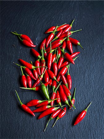 pimientos rojos - Small chilli peppers scattered on slate Foto de stock - Sin royalties Premium, Código: 659-08906703