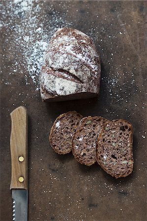 Wholemeal bread dusted with flour, sliced Photographie de stock - Premium Libres de Droits, Code: 659-08906808