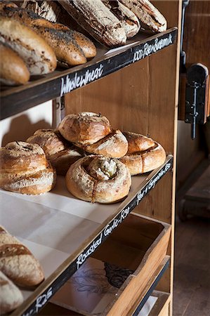 Various loaves of bread and rolls on a shelf in a bakery Foto de stock - Sin royalties Premium, Código: 659-08902617