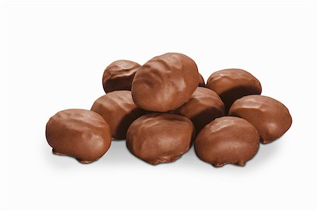 simsearch:659-08902725,k - Chocolate-coated nuts on a white surface (close-up) Foto de stock - Sin royalties Premium, Código: 659-08902707