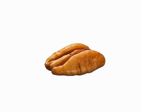 simsearch:659-08902725,k - A shelled peacan nut on a white surface (close-up) Foto de stock - Sin royalties Premium, Código: 659-08902714