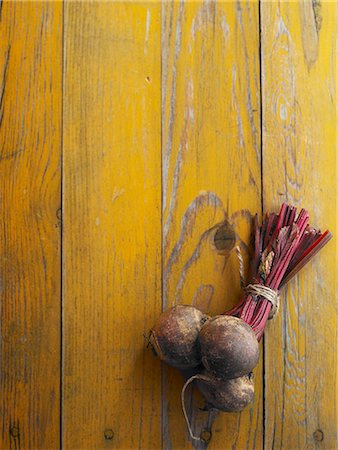 A bundle of beetroot on a yellow wooden table Stock Photo - Premium Royalty-Free, Code: 659-08902980