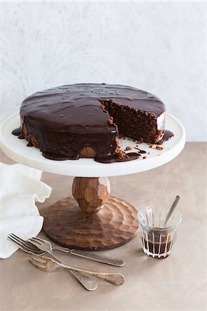 pictures of chocolate gateau cake - Whole Chocolate Frosted Cake on Cake Stand Stock Photo - Premium Royalty-Free, Code: 659-08903122