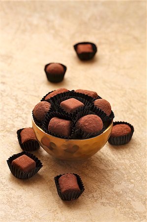 simsearch:659-08903379,k - Chocolate truffles in a golden bowl and next to it Foto de stock - Sin royalties Premium, Código: 659-08903175