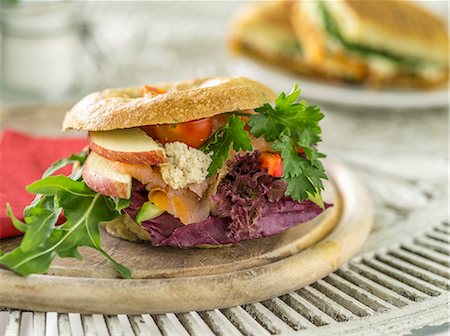 A bagel with salmon, cream cheese, lettuce, apples and tomatoes Stock Photo - Premium Royalty-Free, Code: 659-08903544