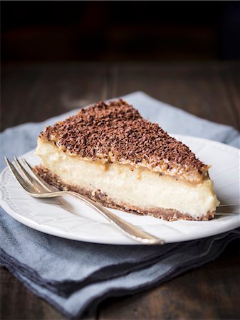 A slice of vegan millet cheesecake with date caramel on a dark surface Photographie de stock - Premium Libres de Droits, Code: 659-08903997