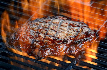 A ribeye steak on a flaming barbecue Stock Photo - Premium Royalty-Free, Code: 659-08939899
