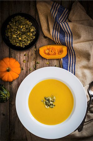 simsearch:659-08896242,k - Cream of pumpkin soup with pumpkin seeds (seen from above) Foto de stock - Sin royalties Premium, Código: 659-08939950