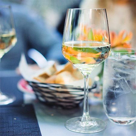 A glass of white wine outside on a table Stock Photo - Premium Royalty-Free, Code: 659-08939999