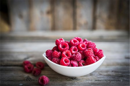 simsearch:659-03537384,k - A bowl of fresh raspberries on a rustic wooden surface Foto de stock - Royalty Free Premium, Número: 659-08940017