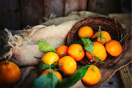 simsearch:659-06187804,k - Mandarins with leaves in a basket on a rustic wooden surface Stock Photo - Premium Royalty-Free, Code: 659-08940022