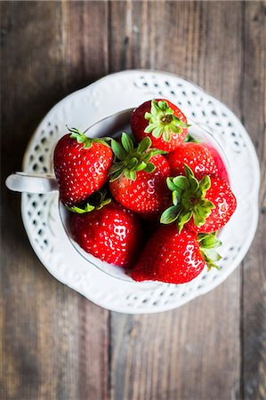 simsearch:659-06151878,k - Fresh strawberries in a teacup on a wooden table Photographie de stock - Premium Libres de Droits, Code: 659-08940031