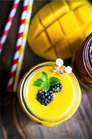 simsearch:659-08939956,k - Layered mango and berry smoothie garnished with blackberries Photographie de stock - Premium Libres de Droits, Code: 659-08940040