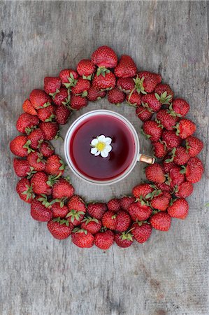 A cup of strawberry tea surrounded by fresh strawberries (seen from above) Stock Photo - Premium Royalty-Free, Code: 659-08940342