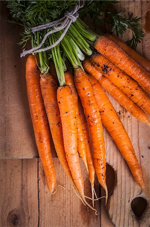 A bundle of fresh carrots on a wooden board Photographie de stock - Premium Libres de Droits, Code: 659-08940391