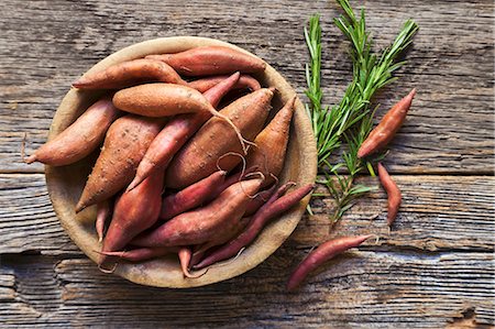 Sweet potatoes in a wooden bowl with sprigs of rosemary Foto de stock - Sin royalties Premium, Código: 659-08940518