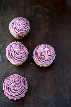 simsearch:659-07598717,k - Four blueberry cupcakes on a dark wooden table Foto de stock - Sin royalties Premium, Código: 659-08940593