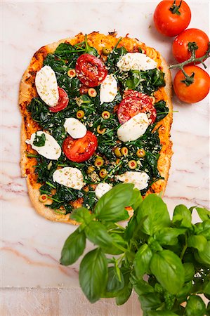 simsearch:659-01857570,k - Spinach pizza with mozzarella and tomatoes Foto de stock - Sin royalties Premium, Código: 659-08940884