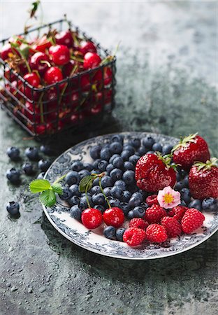 simsearch:659-08147459,k - Fresh berries on a plate and sour cherries in a wire basket Photographie de stock - Premium Libres de Droits, Code: 659-08940938