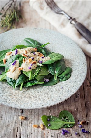 simsearch:659-07028992,k - Vegan spinach salad with a garlic dressing, pine nuts and edible flowers Photographie de stock - Premium Libres de Droits, Code: 659-09124230