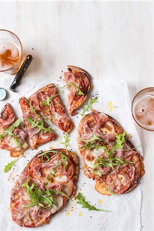 simsearch:659-08896722,k - Quick pita bread pizza with sliced tomatoes, prosciutto, mozzarella and fresh rocket Foto de stock - Sin royalties Premium, Código: 659-09124954