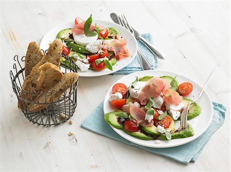 Avocado with goat's cheese, raw ham, cherry tomatoes and wholegrain baguette slices Stock Photo - Premium Royalty-Free, Code: 659-09124989