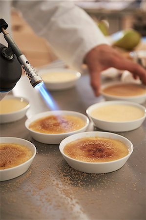 simsearch:6115-06778975,k - Crème brûlée being caramelised Stock Photo - Premium Royalty-Free, Code: 659-09125023