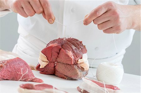 simsearch:659-06153364,k - A joint of roast beef being tied with string Stock Photo - Premium Royalty-Free, Code: 659-09125213