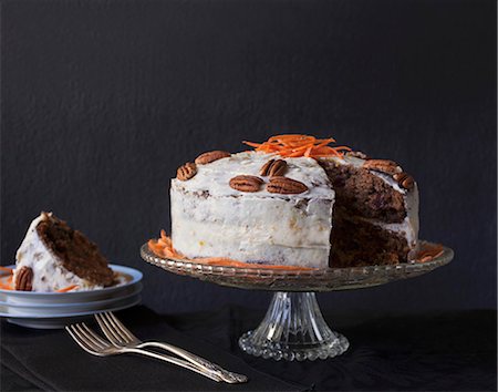 Carrot cake with pecan nuts and a piece missing on a cake stand Photographie de stock - Premium Libres de Droits, Code: 659-09125276