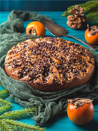 diospyros kaki - Whole wheat cake with persimmons topped with raw cocoa nibs and walnuts Foto de stock - Sin royalties Premium, Código: 659-09125722