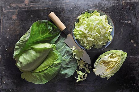 simsearch:659-06494082,k - Pointed cabbage, whole, halved and sliced, in a ceramic bowl with a knife on a black baking tray Fotografie stock - Premium Royalty-Free, Codice: 659-09125771