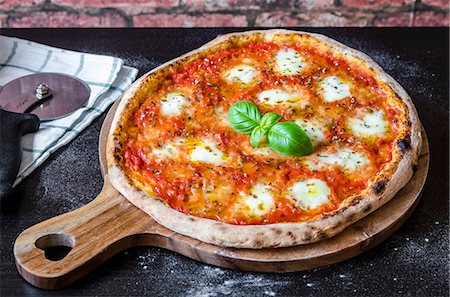 fresh vegetable - Classic pizza margherita made with a sourdough base, tomato sauce with oregano and olive oil, mozzarella cheese and fresh basil Stock Photo - Premium Royalty-Free, Code: 659-09125885