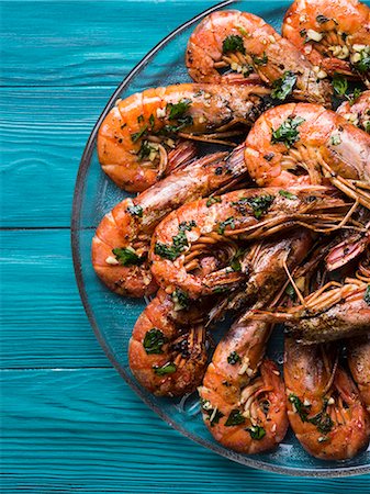 simsearch:659-03537201,k - Grilled shrimps served on a dish with olive oil, parsley and garlic over dark green wooden background Photographie de stock - Premium Libres de Droits, Code: 659-09125943