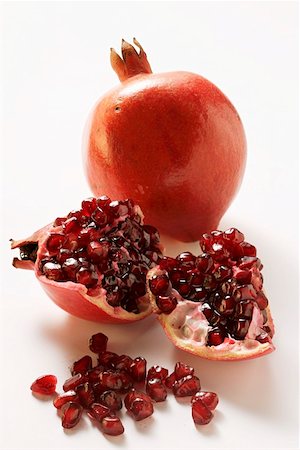 pomegranate cut up - Two pomegranates, one halved, pomegranate seeds Foto de stock - Sin royalties Premium, Código: 659-01844817