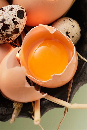 egg still life - Eggs, egg broken open and quail’s eggs in bowl with straw Stock Photo - Premium Royalty-Free, Code: 659-01844834