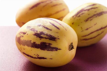 simsearch:659-03525527,k - Trois melons pepino sur fond violet Photographie de stock - Premium Libres de Droits, Code: 659-01844929