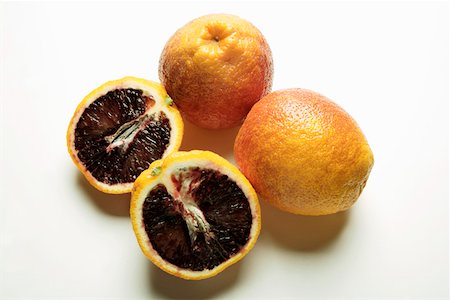 Three blood oranges, one halved Foto de stock - Sin royalties Premium, Código: 659-01844979