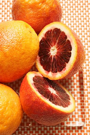 Blood oranges, whole and halved, on glass plate Stock Photo - Premium Royalty-Free, Code: 659-01844973