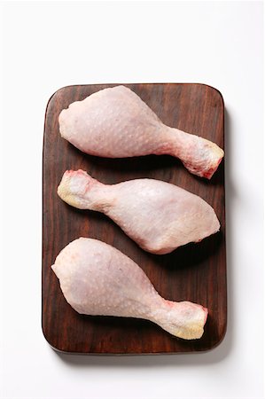 Three raw chicken legs on chopping board Foto de stock - Sin royalties Premium, Código: 659-01845311